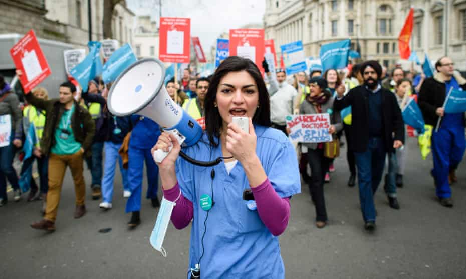 A demonstrator in scrubs uses a loudspeaker as she participates in a protest in central London. So far this year, 37% of the £6bn worth of clinical contracts put out to tender have gone to private companies.