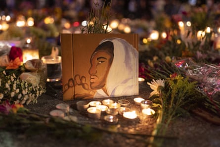Candles and flowers surround a painting of a young man