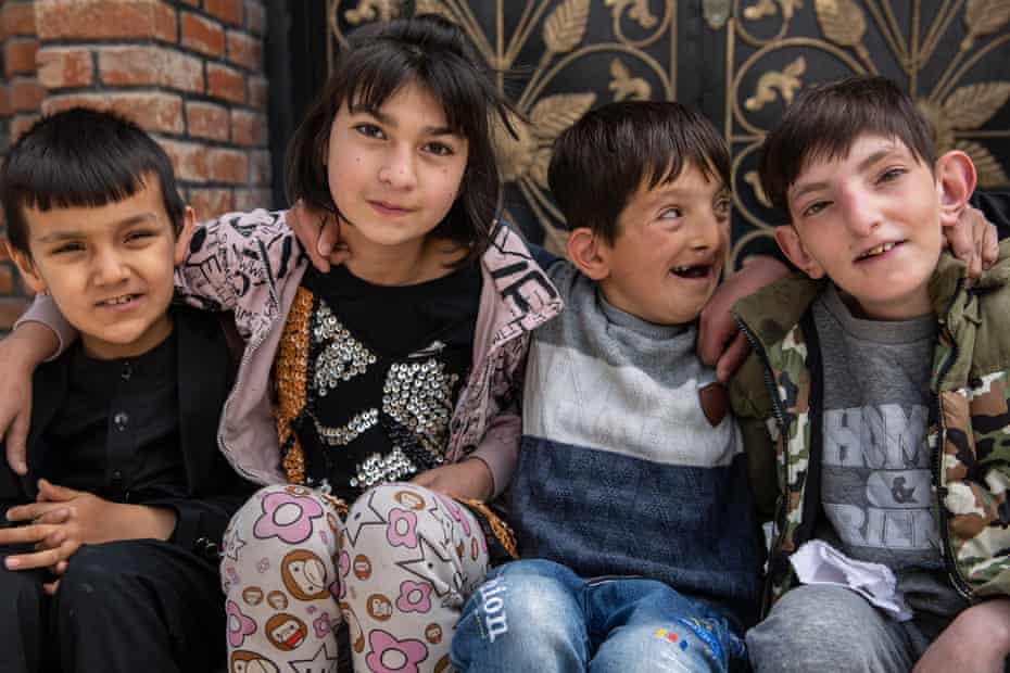 Children sit outside the Fatima Khalil school in Kabul
