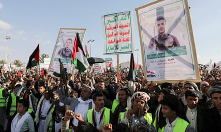Houthi supporters hold up pictures of killed fighters