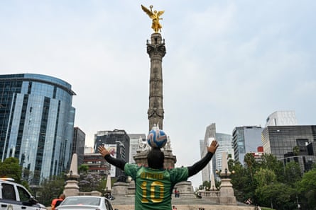 Diego Ivan Carmona balancing football on his head in front of the Angel of Independence monument