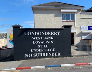 The Bogside murals are not affiliated to any political group, unlike this loyalist mural, set next to a curb painted in the red white and blue of the British flag.