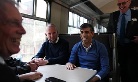 Rishi Sunak (C) with James Daly (L), the Conservative candidate for Bury North talks with East Lancashire Railway volunteers on a train heading for Bury train station during a Conservative general election campaign event on May 31, 2024 in Bury