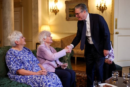 Keir Starmer shakes the hand of an elderly woman.