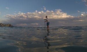 A man paddleboards at Bondi beach in Sydney during a heatwave in February.