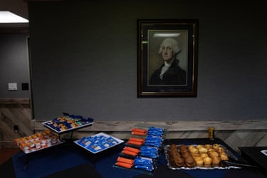 A framed portrait of George Washington hangs above a table of snacks on board.