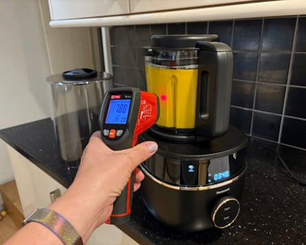 A full soup maker on a kitchen worktop being tested using a thermometer probe.