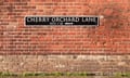 A street sign for Cherry Orchard Lane fixed to a brick wall