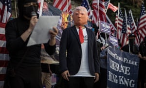A pro-democracy protester wears a face mask of Donald Trump during a March of Gratitude rally to say thank you to the US for their support in December last year in Hong Kong, China.
