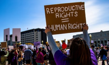 a person holds a sign that reads "reproductive rights = human rights"