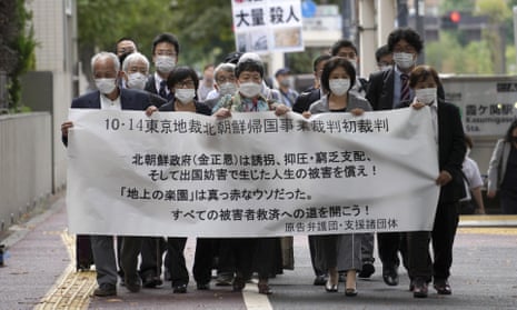Plaintiffs and their supporters walk towards the court in Tokyo, from where they are suing Kim Jong-un’s regime