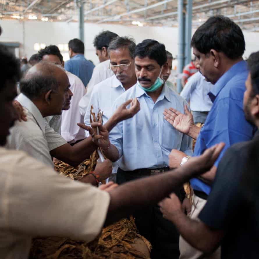 Periyapatna, India. P Jayarama (centre), auction superintendent of the Tobacco Board auction floor, accepting bids for the exhibited tobacco bales.