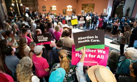 Demonstrators and lawmakers gather with signs and placards in the lobby of the South Carolina statehouse.