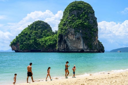 People walking across Phra Nang Beach in Krabi, Thailand