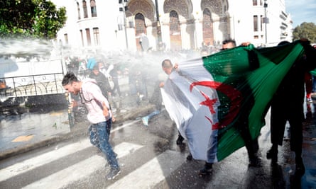 Algerian riot police spray anti-government protesters with water during a demonstration in the capital Algiers.