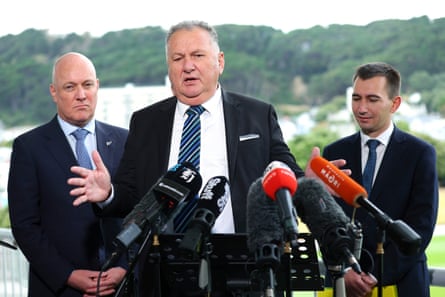 Minister Shane Jones speaks while prime minister Christopher Luxon (left) and minister Simeon Brown look in March 2024.