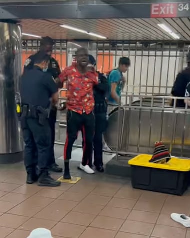 A screenshot of a video John Ajillo posted on his instagram showing him getting arrested by the NYPD for performing in the Herald Square subway station.