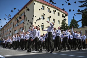 Military cadets throw their hats into the air