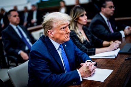 trump sits at table among others, frowning