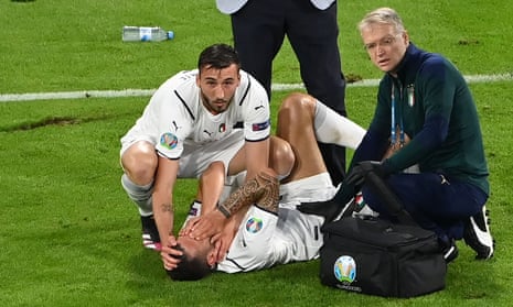 Italy’s defender Leonardo Spinazzola gets treatment before being stretchered off.