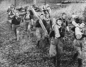Women of the Forestry Commission section of the Women’s Land Army (WLA) carry logs on their shoulders ready to be stacked at Culford Camp, near Bury St Edmunds, England in December 1941