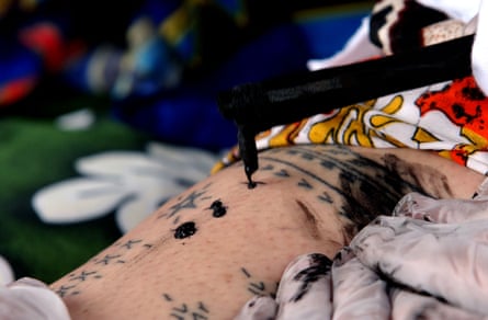 A young Samoan woman is inked with a traditional tattoo