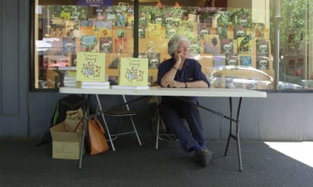 leunig sits outside a bookshop at a signing table