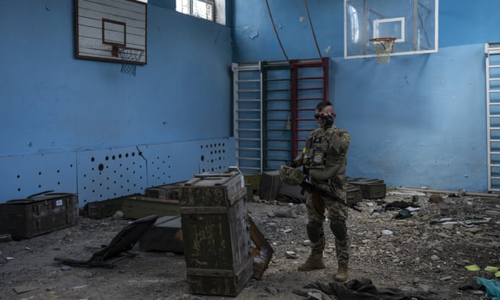 A Ukrainian serviceman inspects a school damaged during a battle between Russian and Ukrainian forces in the village of Vilkhivka, on the outskirts of Kharkiv.