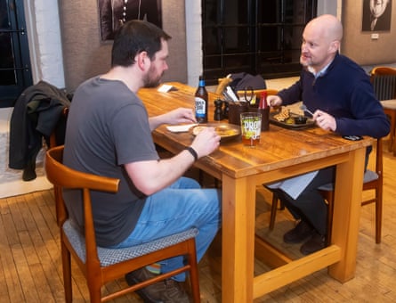 Two men facing each other across a restaurant table