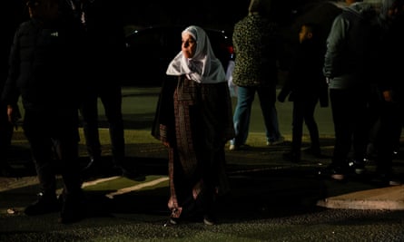 Light shines on a Palestinian woman who is surrounded by shadow