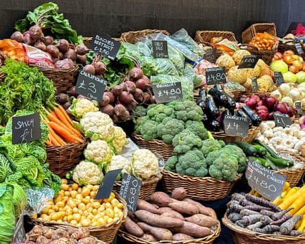 Baskets of fresh vegetables on a grocery stall in Borough Market. No people.
