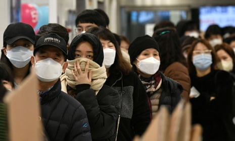 People wait in a line to buy face masks at a retail store in the southeastern city of Daegu 
