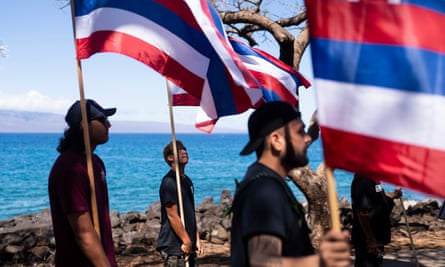 people holding flags with sea in the background
