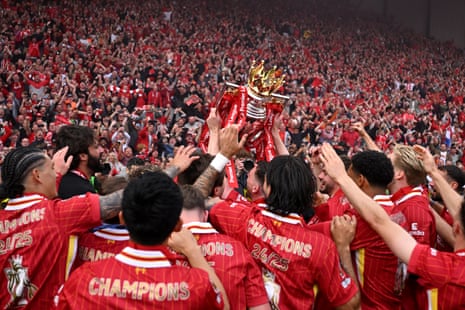 Liverpool’s players celebrate with the Premier league trophy in front of their fans at Anfield