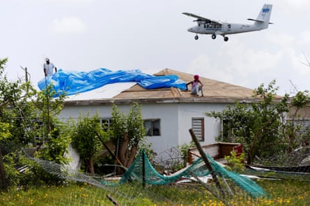 Devon Warner and his daughter Che Niesha work on the roof of a home in Codrington, Barbuda
