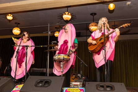 Three women dressed in vagina costumes perform on stage