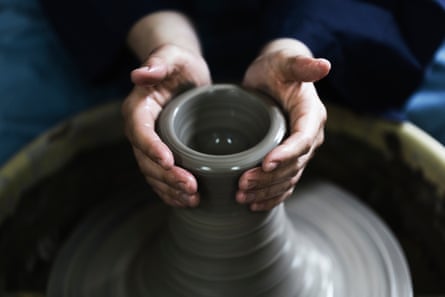 Mains de femme appréciant la poterie.