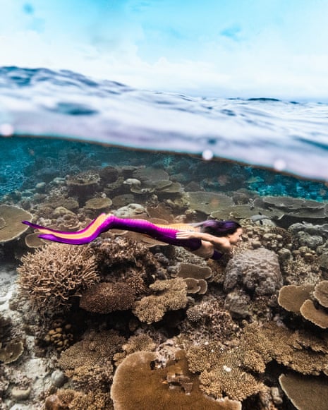 Professional mermaid Mermeow Awn posing on rocks.