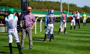 Jockeys observe social distancing guidelines at Newcastle Racecourse.