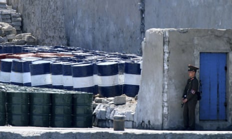 A North Korean soldier guards barrels near Sinuiju, opposite the Chinese border city of Dandong.