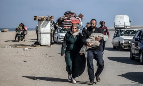 A Palestinian family walks with their baby wrapped in a blanket as Palestinians leave their homes amid ongoing intense Israeli attacks in Khan Yunis, Gaza on January 23, 2024. Thousands of Palestinians were compelled to relocate towards Rafah, situated along the Egyptian border.