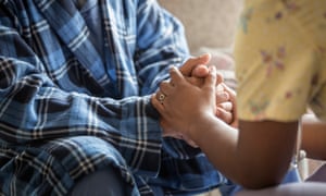 A nurse holding an older person’s hands