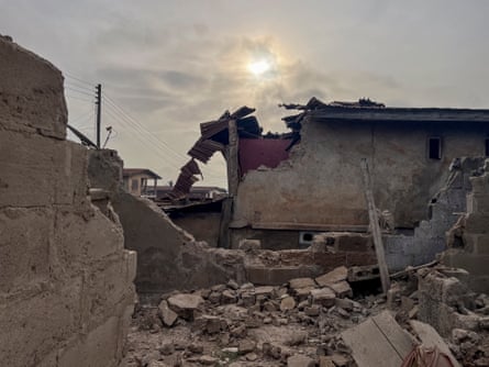 The rubble of a building with the sun setting behind it