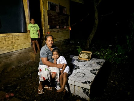 Siiae Olilefauaitu sits outside her house with her children in Samoa, November 2024
