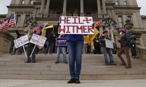 Dawn Perreca protests on the front steps of the Michigan State Capitol building in Lansing, Michigan today. Flag-waving, honking protesters drove past the Michigan Capitol on Wednesday to show their displeasure with Governor Gretchen Whitmer’s orders to keep people at home and businesses locked during the new coronavirus Covid-19 outbreak.