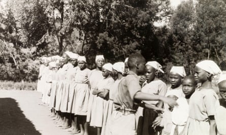 Girls in European clothes lined up outdoors at a mission school