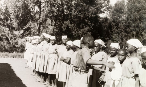 Girls in European clothes lined up outside in a missionary school