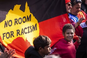 Marchers with a flag saying, 'No room for racism'