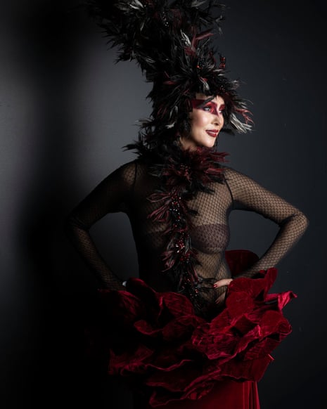 Woman in black mesh top with elaborate tall feather style hair