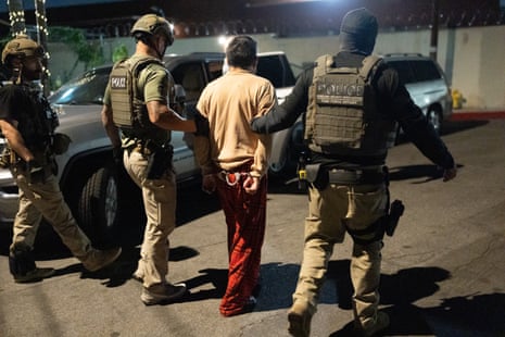 federal agents escort a handcuffed man